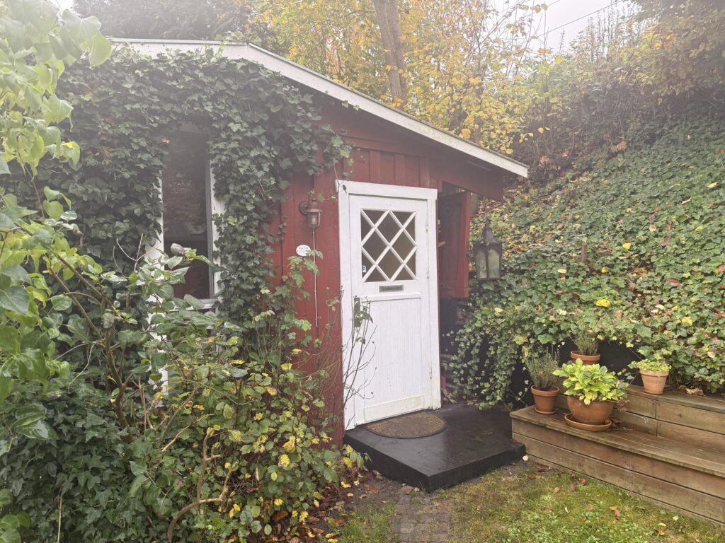Indgangen til psykologklinikken i Skodsborg: rødt anneks med hvid dør og trappe med potteplanter